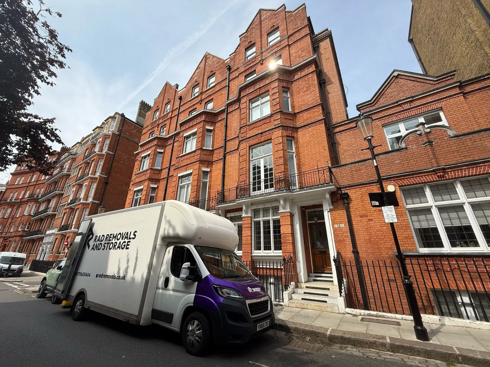 RAD Removals branded van outside elegant Victorian townhouses in Belgravia, London